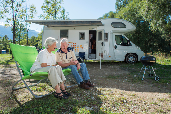 Senior couple having fun camping with camper van