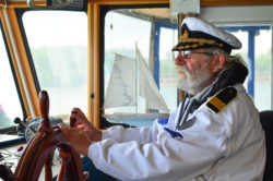 Old experienced captain driving boat